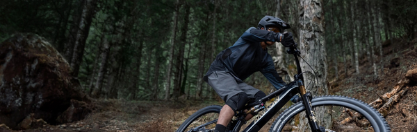 Person riding a mountain bike through a forest